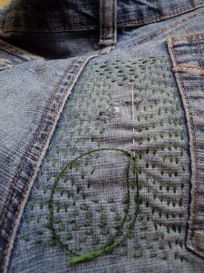 Visible mending green reinforcing stitching