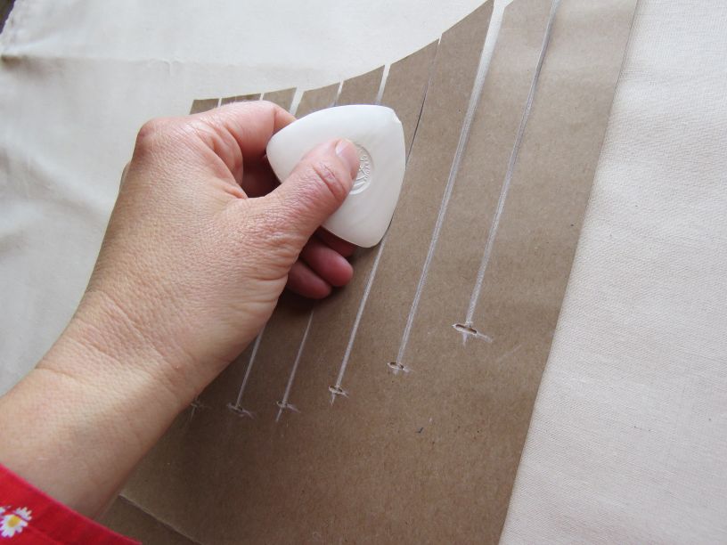 Marking tucks on fabric using a cardboard template.