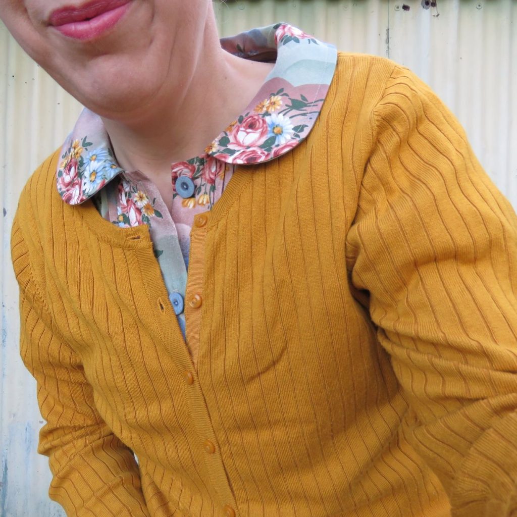 Closeup of Petrea dress in vintage fabric worn with mustard rtw cardigan.