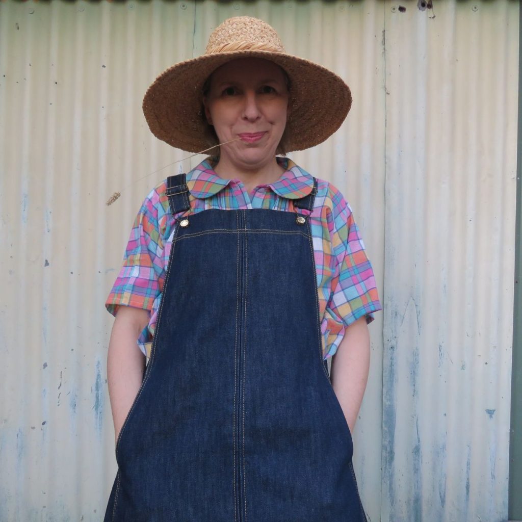 Liz Haywood wearing pink checked Petrea blouse, Smith denim pinafore dress and straw hat.