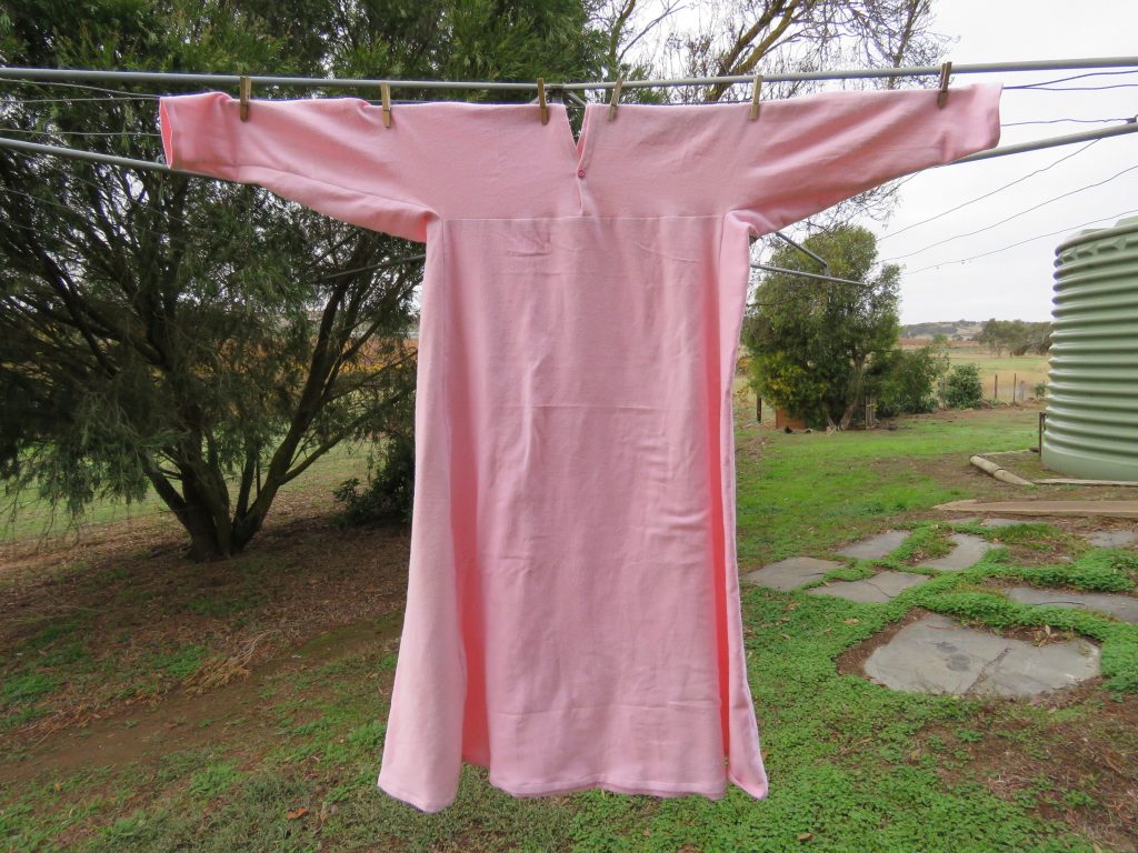 Pink flannelette nightie hanging on clothes line in the country.